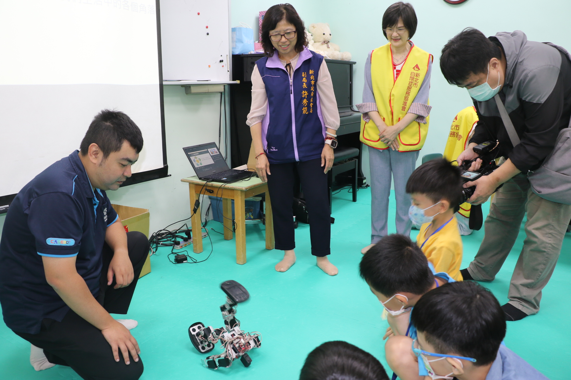 星兒圍觀「鐵蛋」機器人翻滾、跳舞、劈腿 中為許秀能副局長及劉郁純理事長